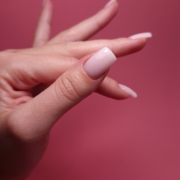 Das Foto zeigt Square-Nägel in der Länge S in einem zarten, milchigen Rosa. Der Daumen ist frontal zu sehen und die anderen Finger sind seitlich zu erkennen.